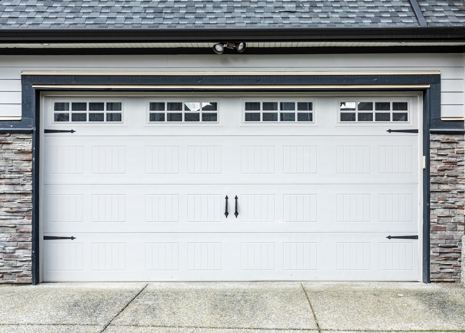 White carriage-style garage door with decorative windows and handles